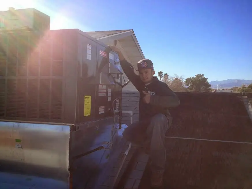 HVAC technician performing Boiler Repair on a rooftop unit in Durham